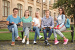 © Africa Studio - Group of young students sitting on bench near university building