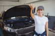 © Wavebreak Media - Female mechanic in garage holding car key