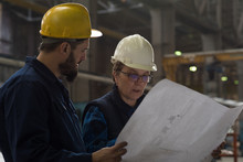 Technician Discussing Blueprint With His Colleague