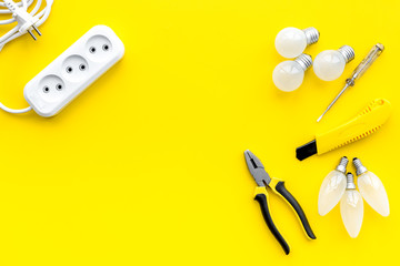 Wall Mural - Electrical accessories at home. Bulbs, socket outlet, cabel on yellow background top view copy space