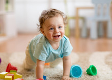 Happy Baby Boy Playing And Crawling On The Floor At Home