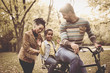 © Mladen - African American Father driving daughter on bike.