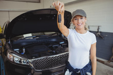 Female Mechanic In Garage Holding Car Key