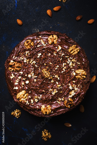 Plakat Domowej roboty czekoladowy tort z dokrętkami, czarny tło, odgórny widok