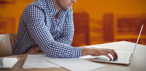 Poster - composite image of businessman using laptop while sitting at