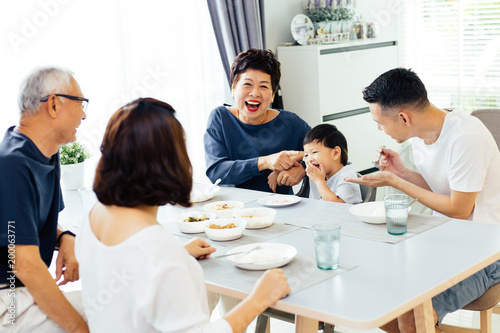 Foto Happy Asian extended family having dinner at home full of laughter and happiness
