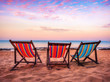 Beautiful colorful beach chairs with a nice white sand, beautiful blue water and stunning sunrise sky at Koh Lanta beach in Thailand in summer