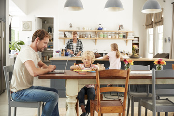 Wall Mural - Young white family busy working in their kitchen