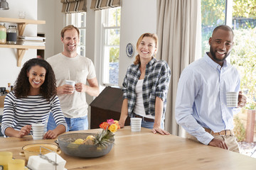 Wall Mural - Young adult friends having coffee at home, looking to camera