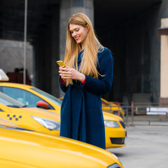 Wall Mural - A young girl calls a taxi by phone.