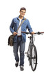 Young man with a bicycle walking towards the camera