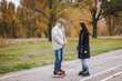 © shchus - A happy pensioner stands on roller skates on the road with his daughter and enjoys good weather in the autumn park.