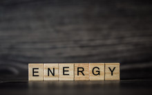 The Word Energy, Consisting Of Light Wooden Square Panels On A Dark Wooden Background