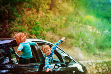 happy little boy and girl travel by car