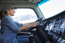 Female Truck Driver In Cab Of Her Commercial Truck