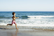 © javiemebravo - young man with long hair  in a swimsuit runs on the shore of the beach