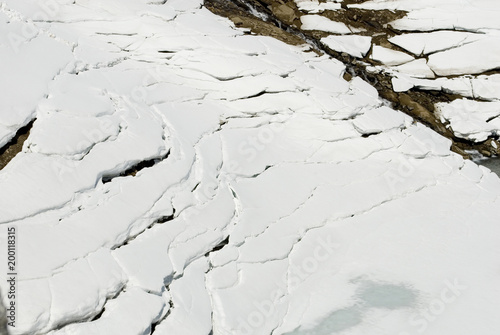 Fotografie, Obraz crevasse in the snow and ice, caused by high temperatures, above a frozen lake o