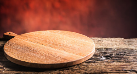 Empty pizza round board  old wooden table and colour blurred background