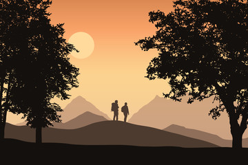 Wall Mural - Two tourists with backpacks in mountain landscape with deciduous forest, under orange sky with sun