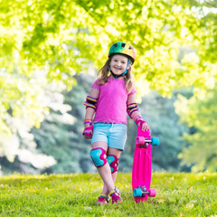 Wall Mural - Child riding skateboard in summer park