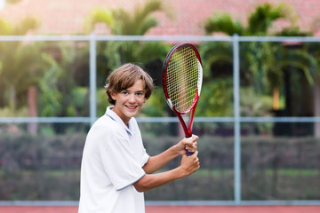 Child playing tennis on outdoor court