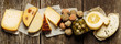 Various types of cheese on wooden table. Top view. Copy space.