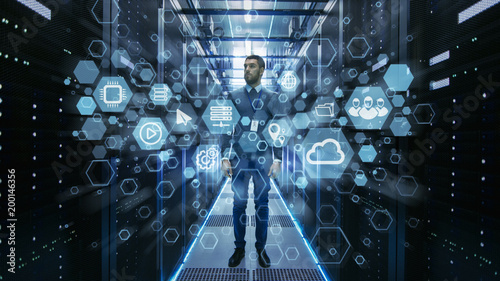 Fotografía Curios IT Engineer Standing in the Middle of a Working Data Center Server Room