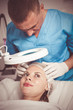 © JackF - Man doctor is analysing skin on face of female patient before the procedure