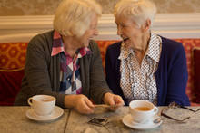 Senior Friends Interacting With Each Other While Having Coffee