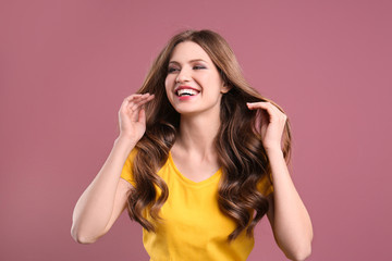 Canvas Print - Portrait of young woman with long beautiful hair on color background