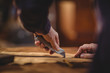 © Wavebreak Media - Shoemaker cutting piece of leather in workshop
