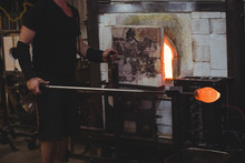 Glassblower Heating A Glass In Furnace