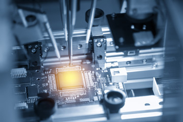 The microchip on the main board in the assembly line in the light blue scene with lighting effect, computer part manufacturing concept.