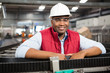 © Wavebreak Media - Smiling male employee standing by conveyor belt in factory