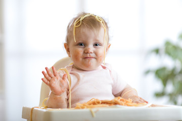 little baby girl eating her dinner and making a mess