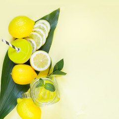 Wall Mural - summer refreshing cocktail with lemon, mint and ice in mason jar on yellow. tropical concept.