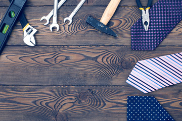 Happy father's day concept with tie, gift and tools empty notebook on a wooden table top view in flat lay style.