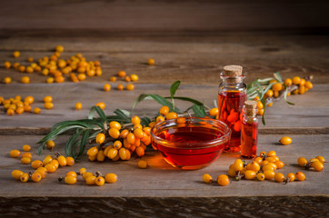 Wall Mural - Sea buckthorn with bottle with sea buckthorn oil  on wooden table