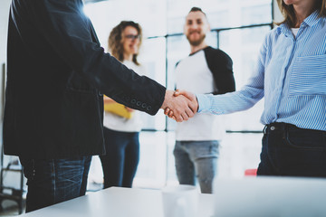 Wall Mural - Concept two coworkers handshaking process.Business partnership handshake.Blurred background.Cropped.