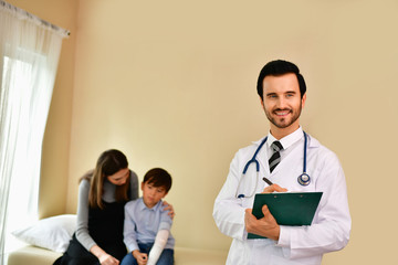 Wall Mural - Smiling doctor posing in the office, he is wearing a stethoscope, medical staff on the hospital background