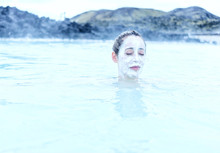Woman In A Hot Spring With A Face Mask On
