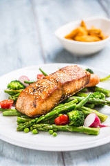 Wall Mural - Roasted salmon steak with asparagos broccoli carrot tomatoes radish green beans and peas. Fish meal with fresh vegetable