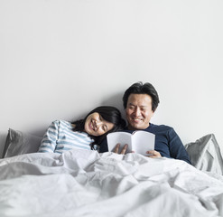 Canvas Print - Asian couple relaxing on bed together