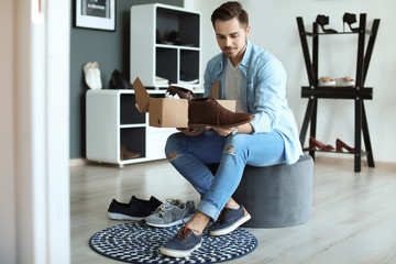 Young man choosing shoes in store