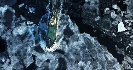 flying above the eastern bosphorus strait. aerial view of the ship slowly moving through ice floes. 