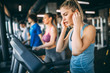 © GutesaMilos - Young people running on a treadmill in health club.