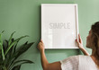 © Rawpixel.com - Girl hanging a frame on a green wall