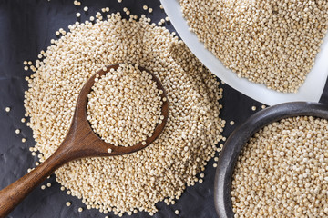 Wall Mural - Quinoa grains with spoon and bowl on black background