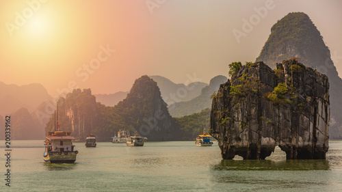 Fotografía Beautiful sunset tourist junks boat anchor floating among limestone cliffs rocks at Ha Long Bay, South China Sea, Vietnam, Southeast Asia