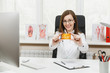 © ViDi Studio - Young smiling female doctor sitting at desk, holding credit card, working with medical documents in light office in hospital. Woman in medical gown in consulting room. Healthcare, medicine concept.